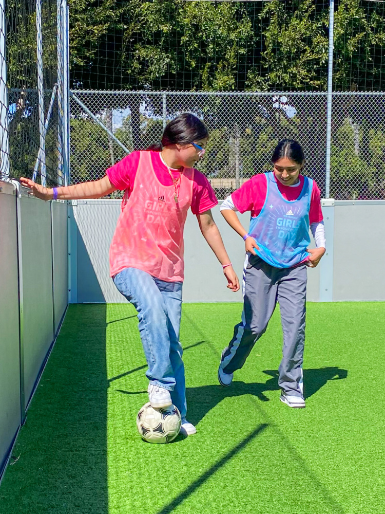 Girls playing soccer, showing skills